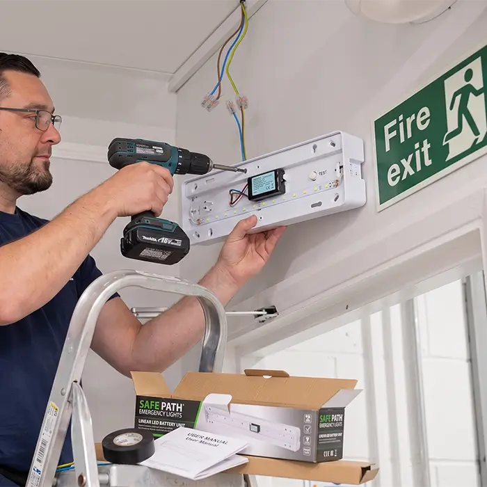 a electrician is installing emergency exit light