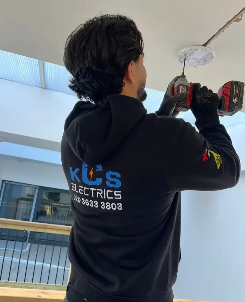 KCS Electrics Electrician is installing smoke detector device