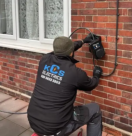 A Electrician installing the ev charger on wall