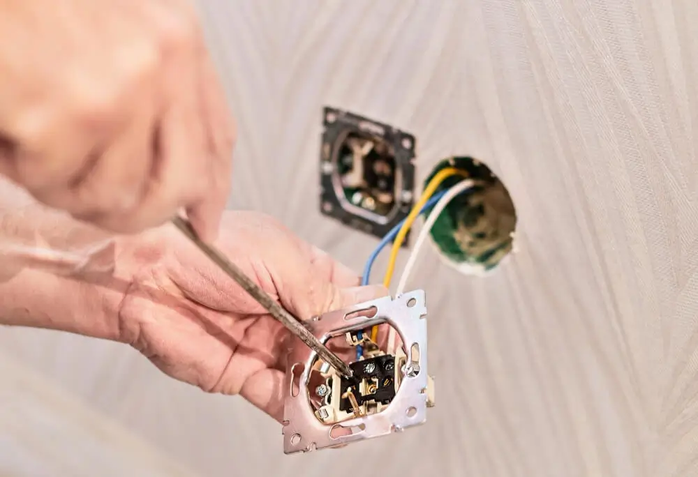 a electrician repairing the wall socket